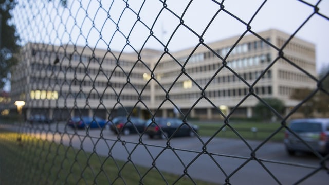 Blick durch Maschendrahtzaun auf Bürogebäude