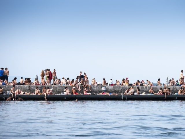 Menschenmenge sucht am See nach Abkühlung