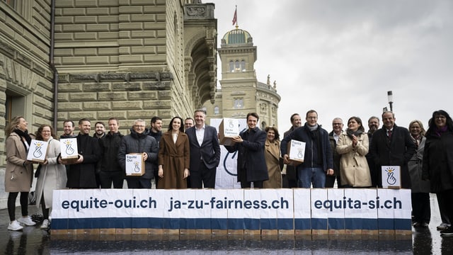 Die Mitte Partei steht vor dem Bundeshaus mit einem Plakat und Kartonkisten. 