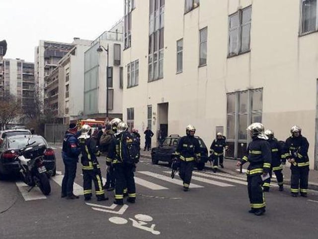 Feuerwehrleute auf der Strasse vor einem Gebäude