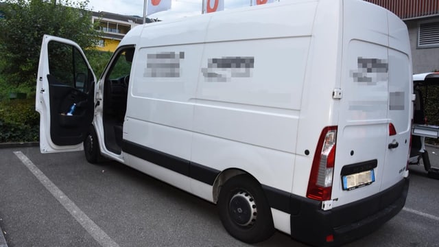 Es ist ein weisser Lieferwagen auf einem Parkplatz.