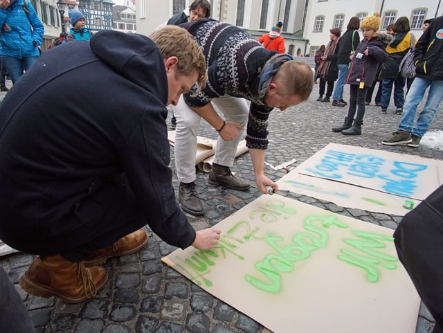 Demonstrierende sprühen Plakate