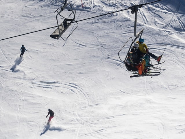 Skipiste mit Skifahrern und einem Sessellift