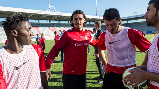 Thun-Spieler Nelson Fereirra zusammen mit Flüchtlingen in der Stockhorn Arena.