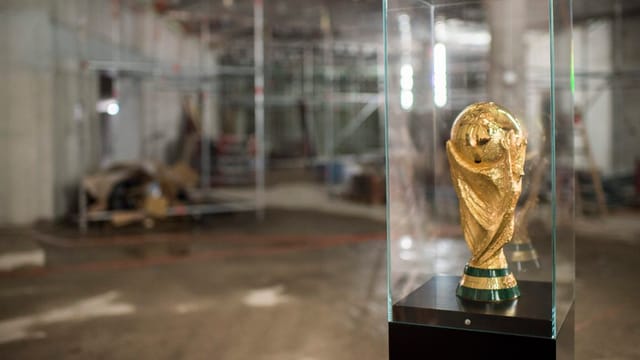 Die goldene WM-Trophäe vor dem Hintergrund von Baugerüsten.