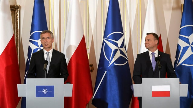 Stoltenberg und Duda vor Nato-Flaggen