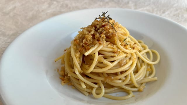 Weisser Teller mit Pasta mit Sardellen und Brösmeli.