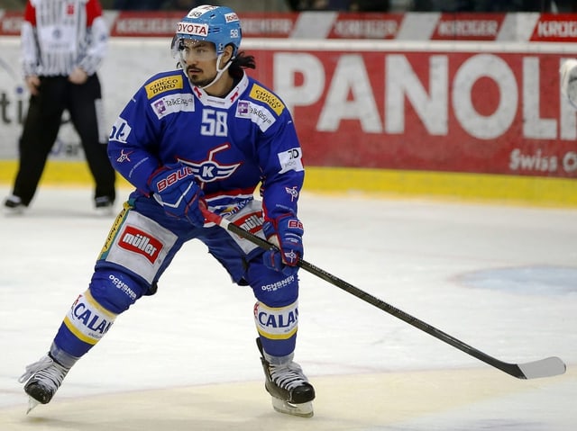 Eishockeyspieler in blauer Ausrüstung auf dem Eis.