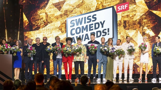 Comedians und beteiligte vom Swiss Comedy Awards 2022 stehen auf der Bühne mit Blumenstrauss