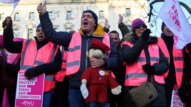 Mehrere Personen protestieren in pinke Leuchtwesten gekleidet