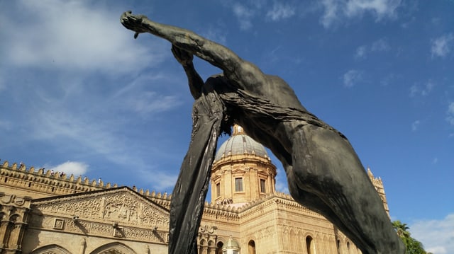 Eine Statue vor einer grossen Kathedrale. 