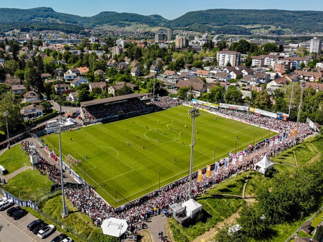 Luftaufnahme eines Fussballstadions mit umliegender Stadtlandschaft.