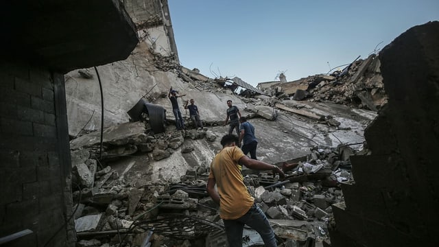 Palästinenser auf den Trümmern eines Hauses in Gaza-Stadt, das von einem israelischen Luftangriff zerstört wurde (19. Mai)