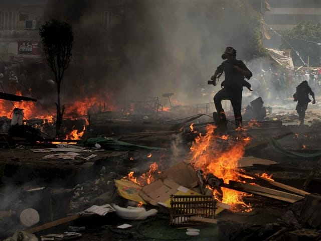 Ein unbekannter Fotograf rennt während der Räumung eines Sit-ins der Anhänger des gestürzten Präsidenten Morsi in der Nähe der Rabaa-Adawiya-Moschee in Kairo, durch Schwaden von Tränengas und Qualm.