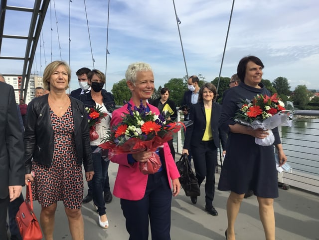 Leute gehen feierlich über Dreiländerbrücke.