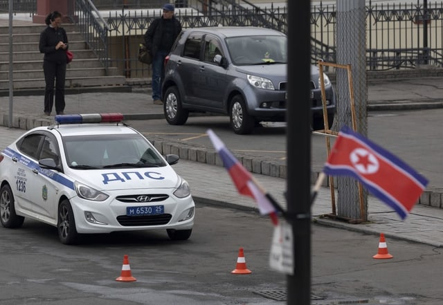 Zwei Flaggen, dahinter ein Polizeiauto