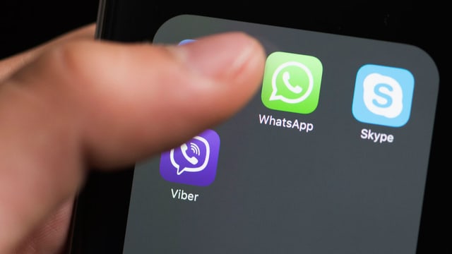 Eine Person tippt auf Messaging-Apps auf ihrem Smartphone.