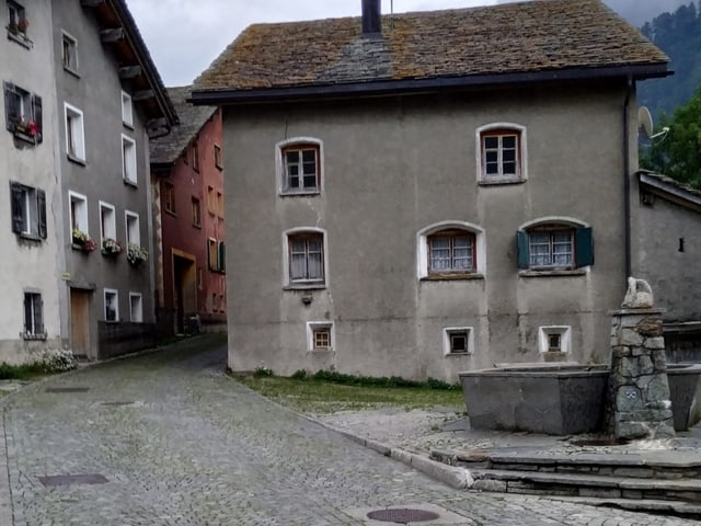 Alte bewohnte Steinhäuser bei Dorfbrunnen in Hinterrhein..