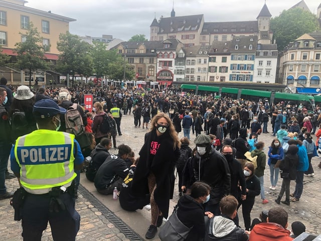 Demo-Teilnehmende und ein Polizist