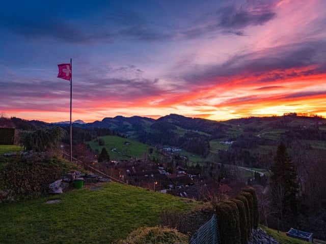 Fahne im Wind vor rotem Morgenhimmel