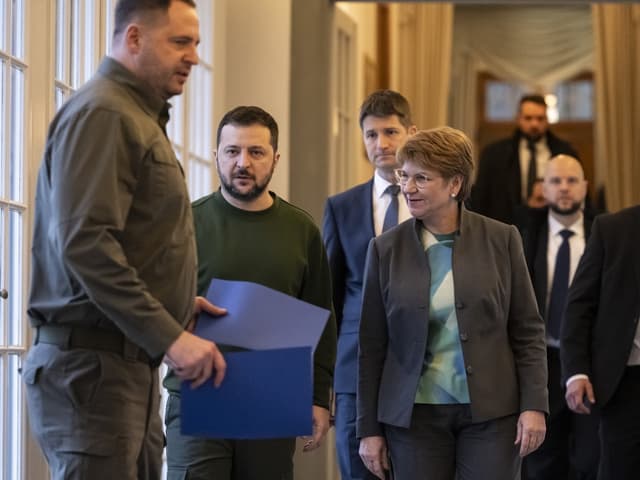 Wolodimir Selenski und Viola Amherd schreiten gemeinsam einen Gang entlang.