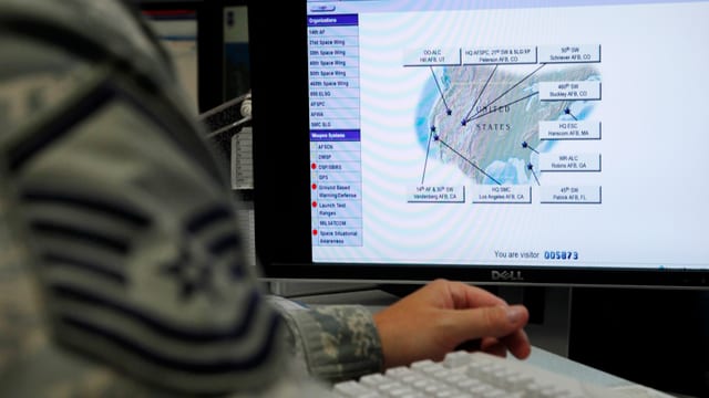 Ein Mann sitzt in Uniform an einem Computer.