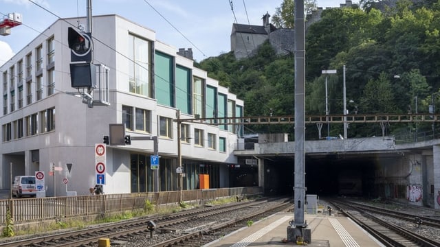 Häuserfassade eines mehrstöckigen Wohnhauses an Bahngleis