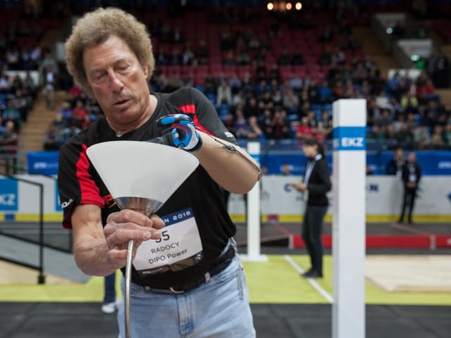 Beim Cybathlon montiert ein Mann mit einer Prothese eine Glühbirne.