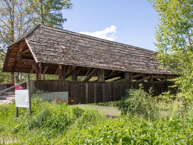 Holzbrücke mit Dach.