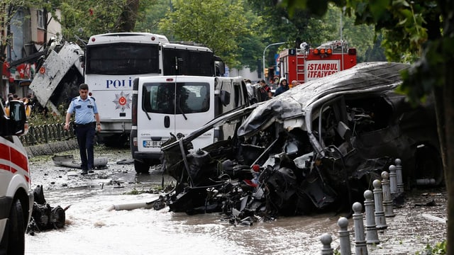 Autowrack und Polizeifahrzeuge am Ort der Explosion