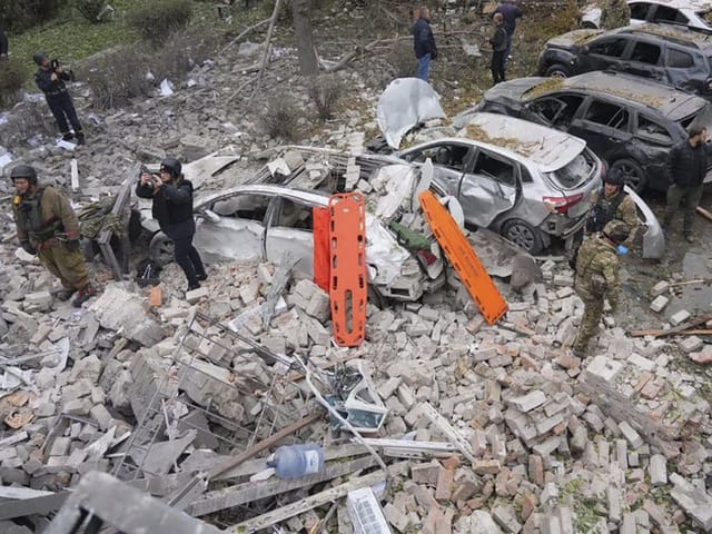 Ukrainische Soldaten und Rettungskräfte räumen Trümmer in der Stadt Saporischja auf.