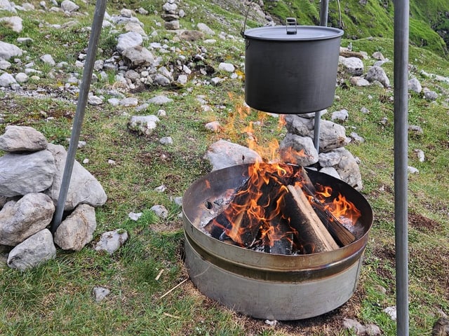 Kochtopf hängt über einem Holzfeuer.