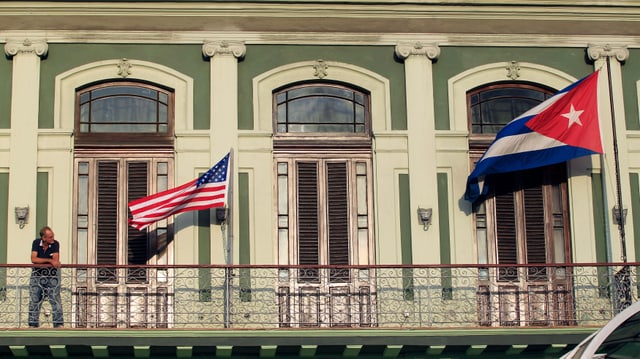 Eine USA- und eine Kubaflagge wehen an einem Gebäude in Havanna.