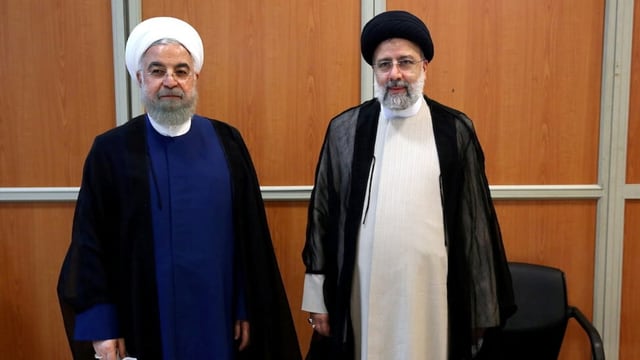 Der ehemalige Präsident Hassan Rohani und Ebrahim Raisi stehen nebeneinander.