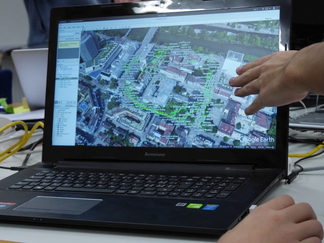 Ein Computerbildschirm, darauf eine Karte mit grünen Punkten, die Wifi-Signale anzeigen.