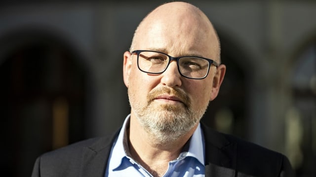 SMPA-Präsident Christoph Bill trägt eine Brille und hat eine Glatze. Er trägt ein blaues Hemd und ein Jacket.