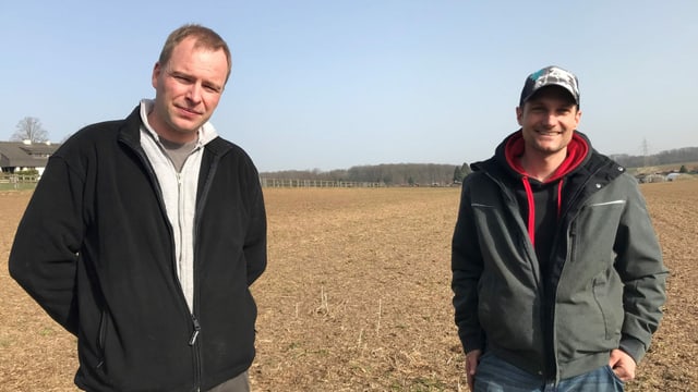 Zwei Männer stehen auf einem Feld