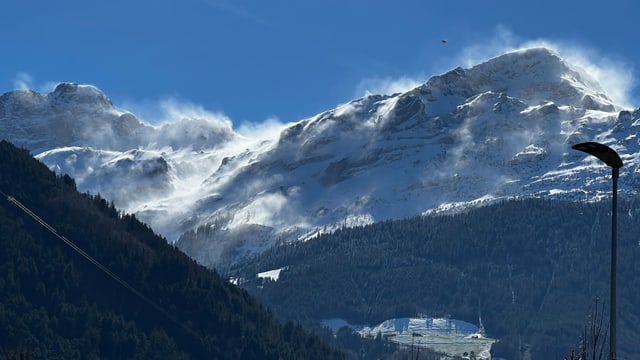 Der Föhn bläst den Schnee über Bergkreten.