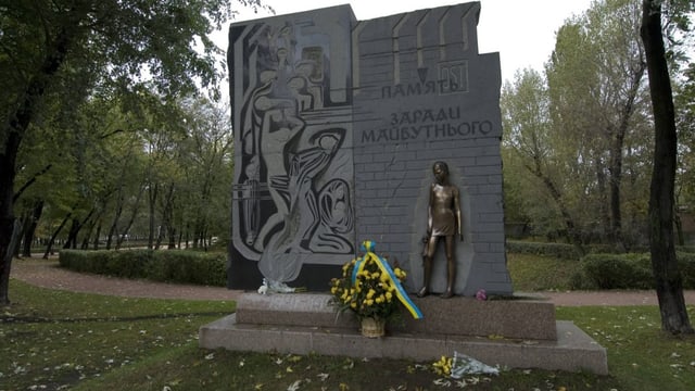 Ein Mahnmal mit ukrainischen Bändern.