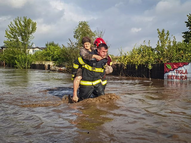 Ein Feuerwehrmann trägt jemanden auf seinen Schultern.