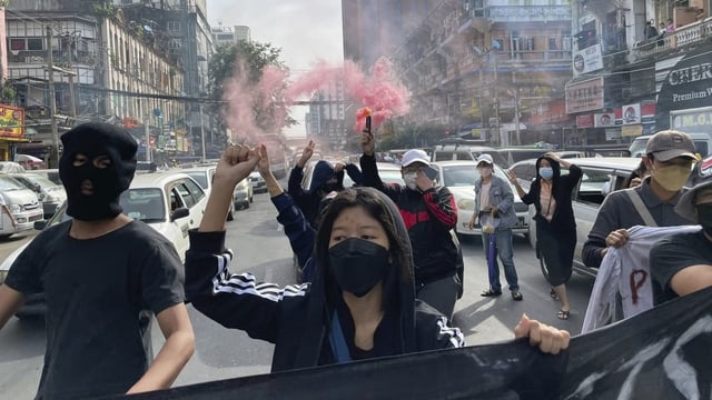 Demonstranten auf der Strasse, die ein Transparent halten