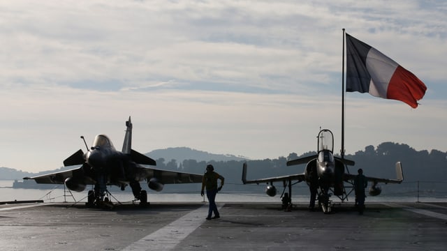 Zwei Kampfjets vor einer französischen Flagge. 