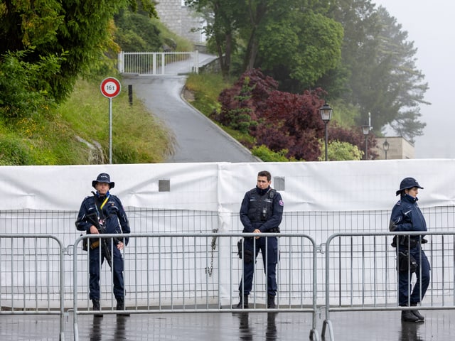 Drei Polizisten stehen vor einer Absperrung am Bürgenstock.