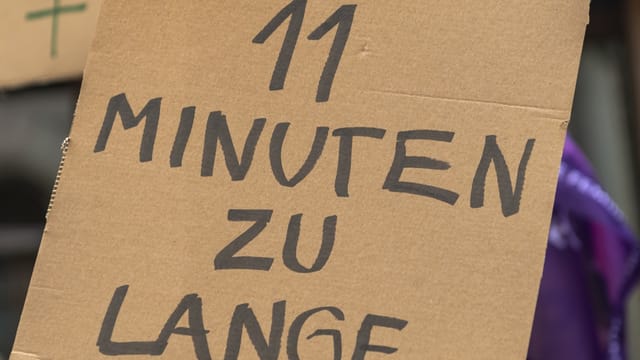 Ein Plakat mit der Aufschrift: «11 Minuten zu lange»