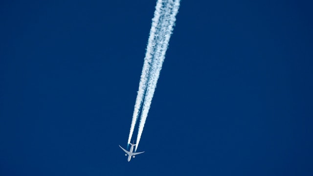 Flugzeug und Kondensstreifen.