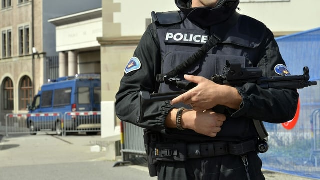 Geneva police with protective vest and submachine gun near a courthouse