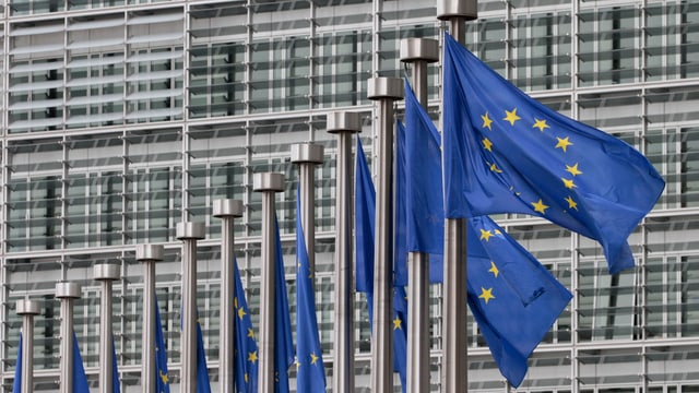 EU-Fahnen im Wind vor EU-Gebäude in Brüssel.