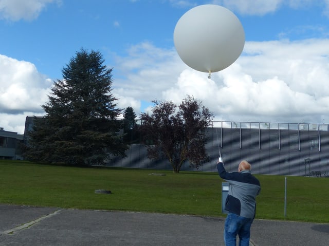 Mann lässt einen Ballon steigen.