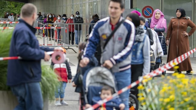 Menschen stehen in einer langen Schlang an.