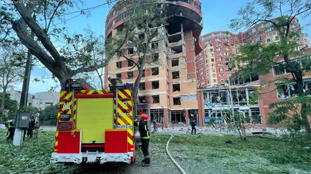 Zerbombtes Haus und Feuerwehr-Auto.